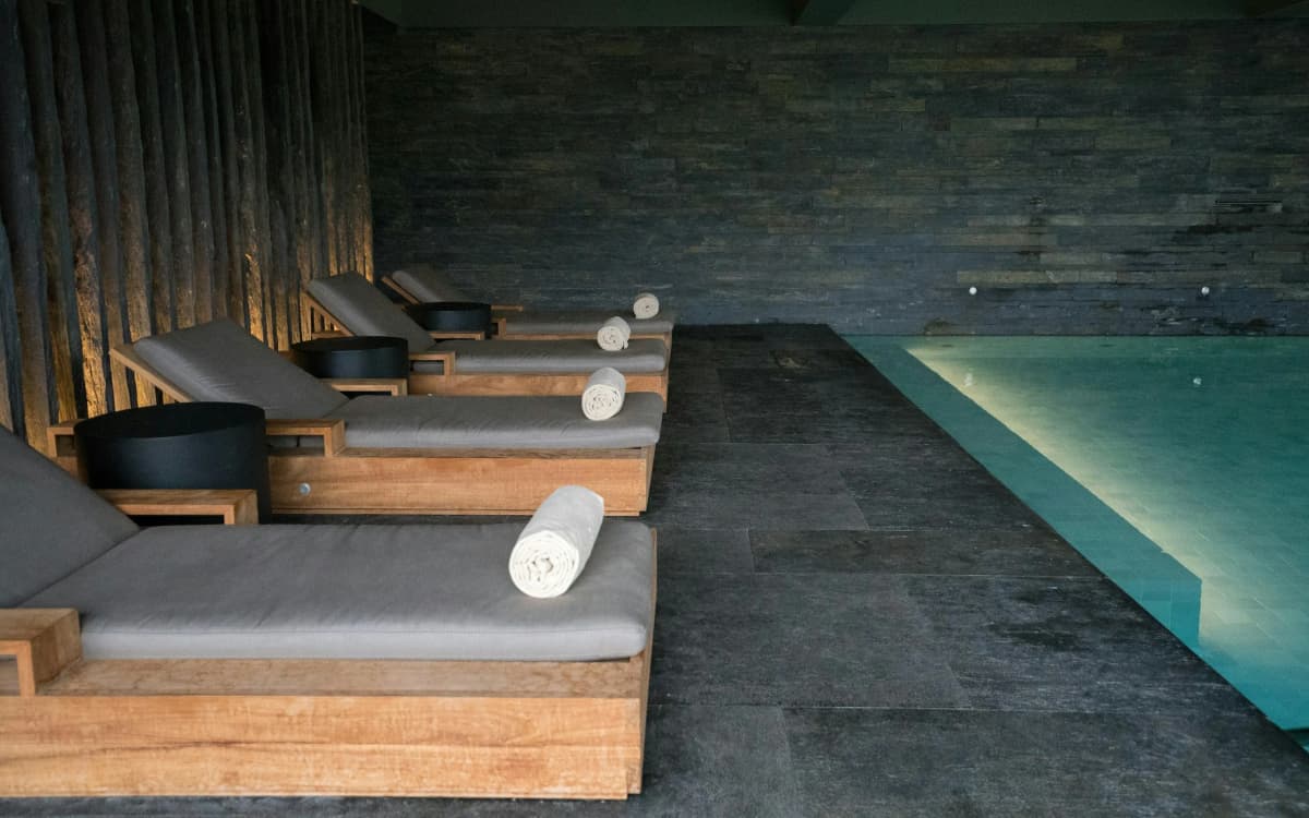 Quiet indoor pool with loungers and folded towels in a hotel spa