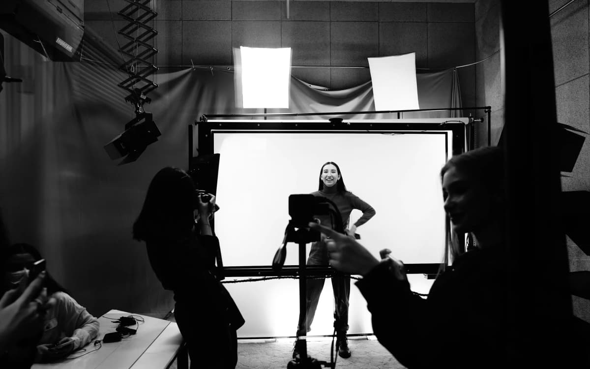 Black and white fashion shoot, the crew in silhouette around the model